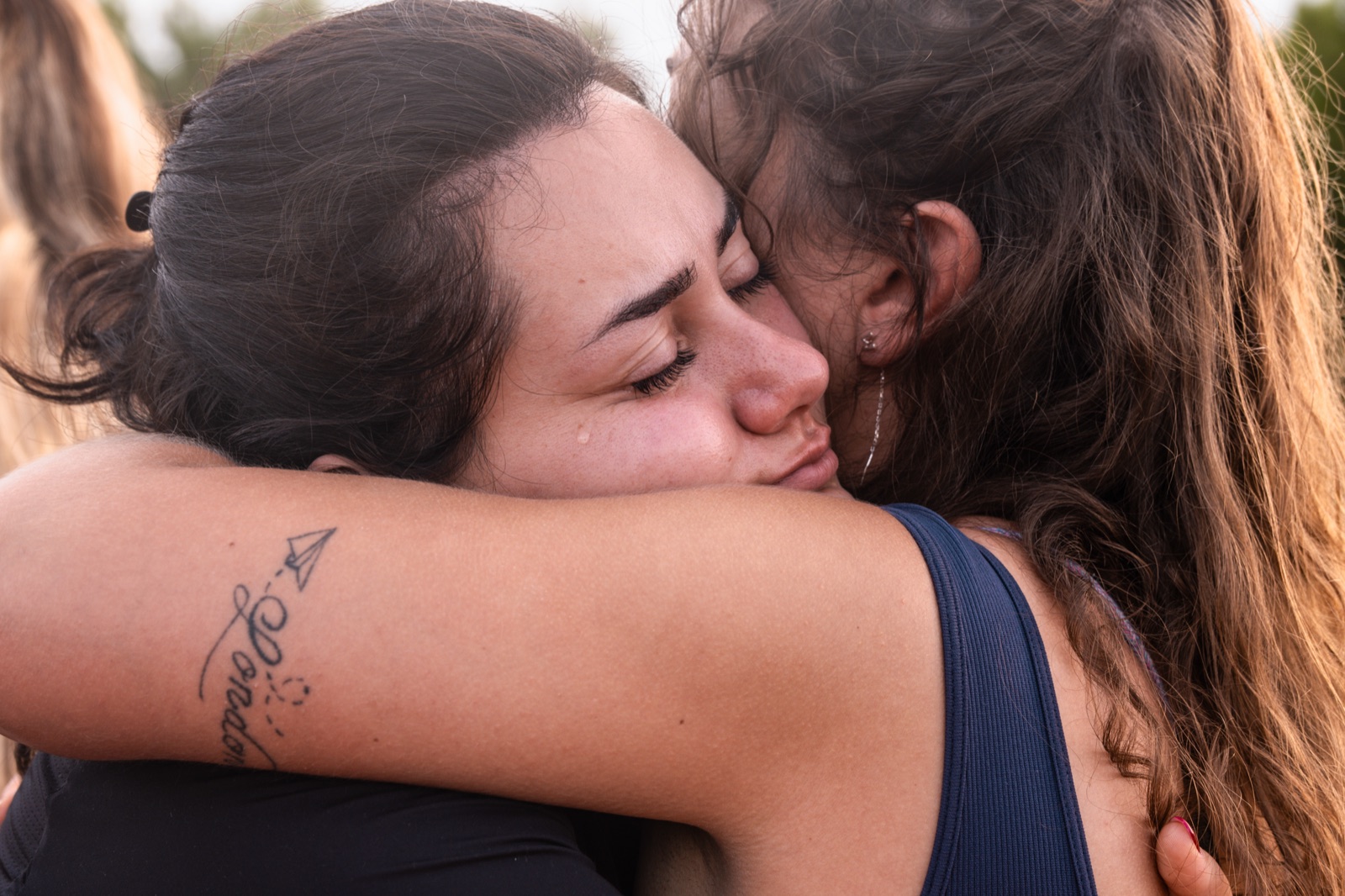 Due partecipanti si abbracciano in lacrime